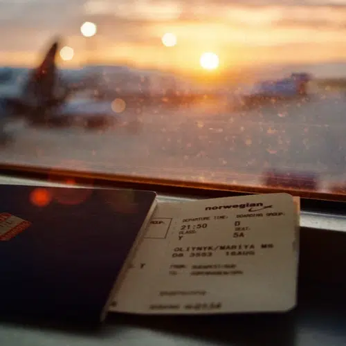 Plane ticket and passport overlooking planes