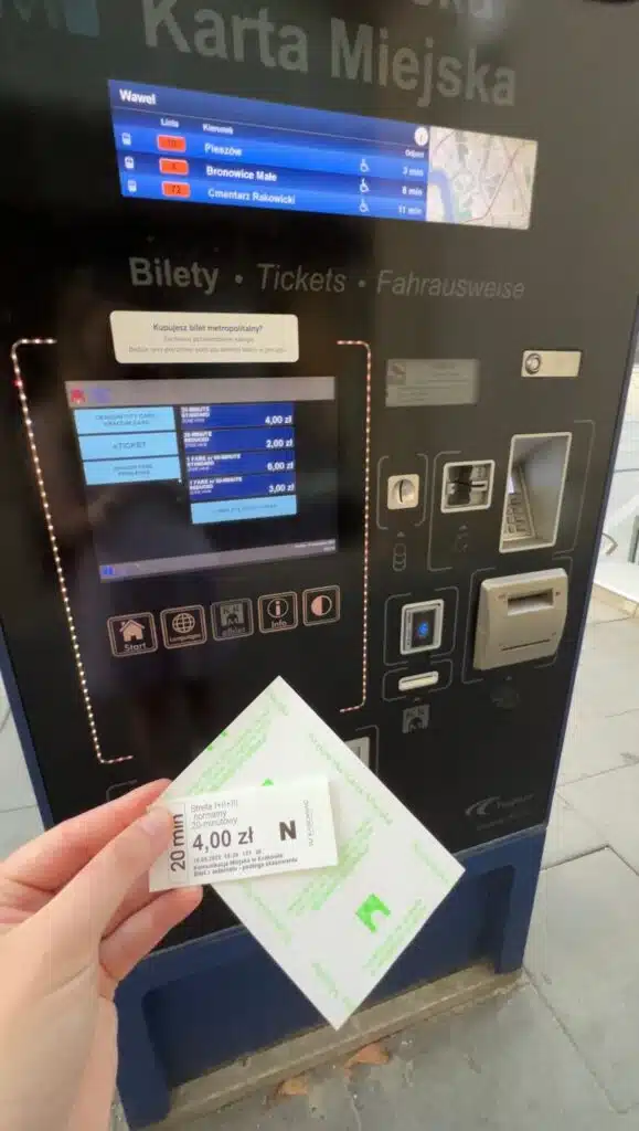 Solo female traveler purchasing a tram ticket at a kiosk in Krakow, Poland