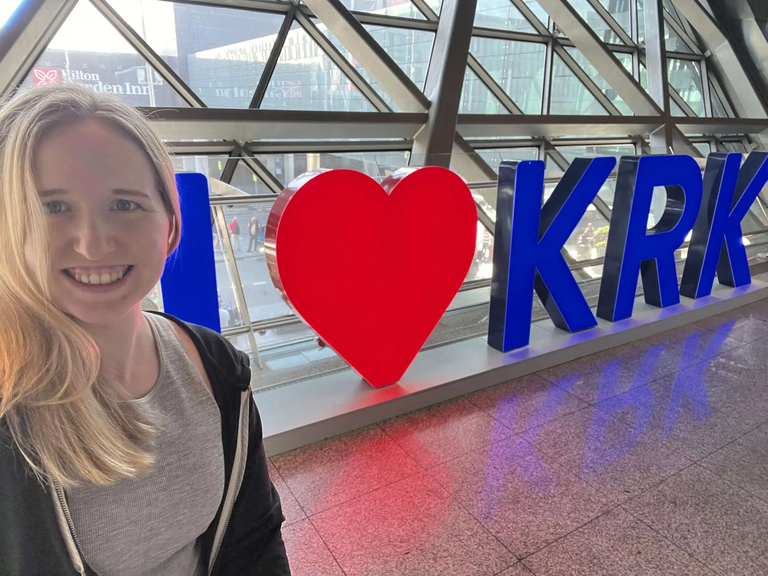 The author in front of the I heart KRK sign at the Krakow airport at the start of her first solo female trip