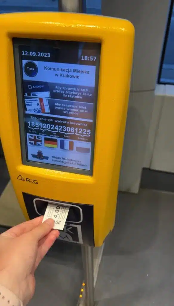 Solo female traveler validating ticket on Krakow tram