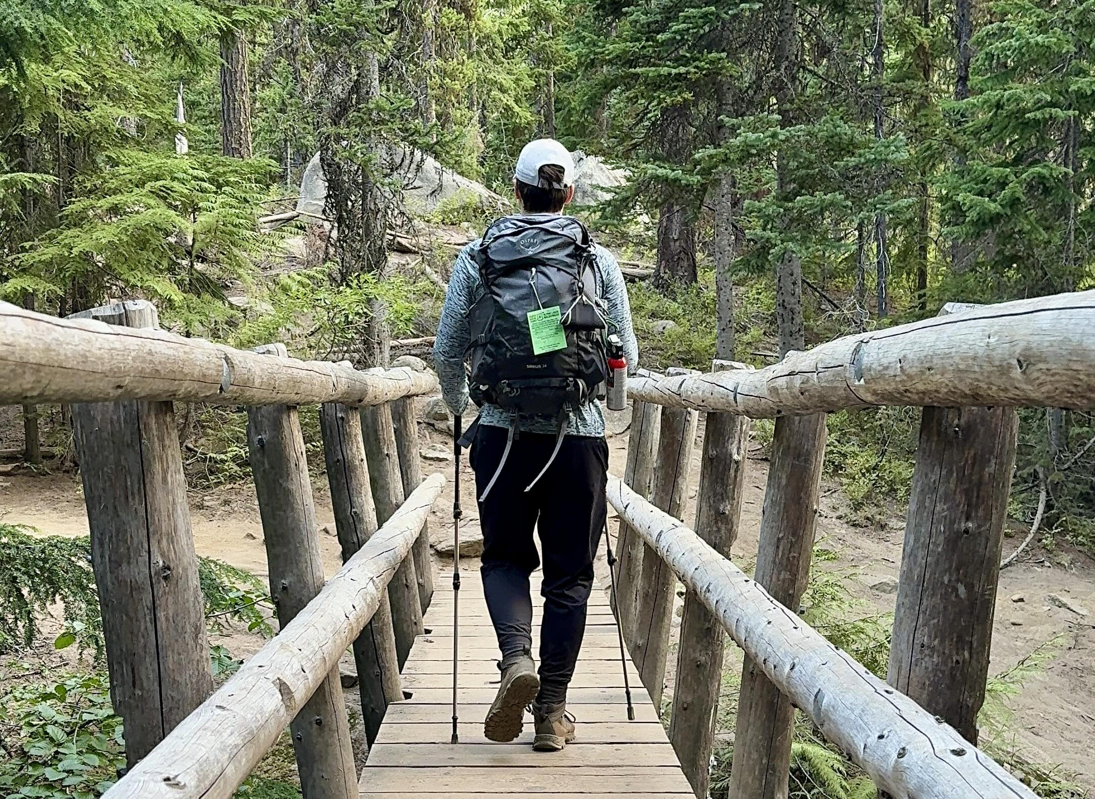 Man crossing a wooden footbridge on the Enchantments thru hike