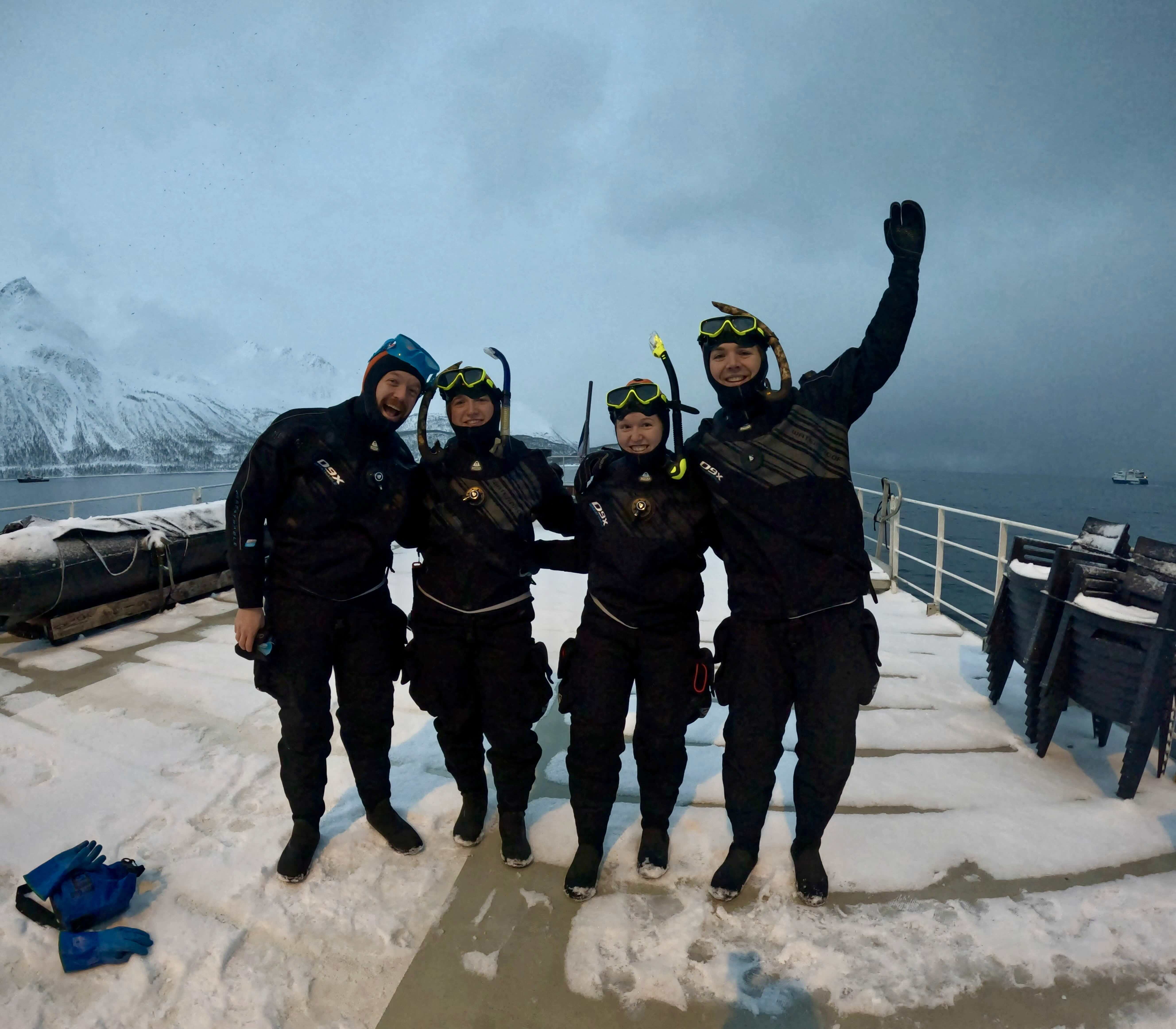 4 people dressed in dry suits to snorkel with orcas