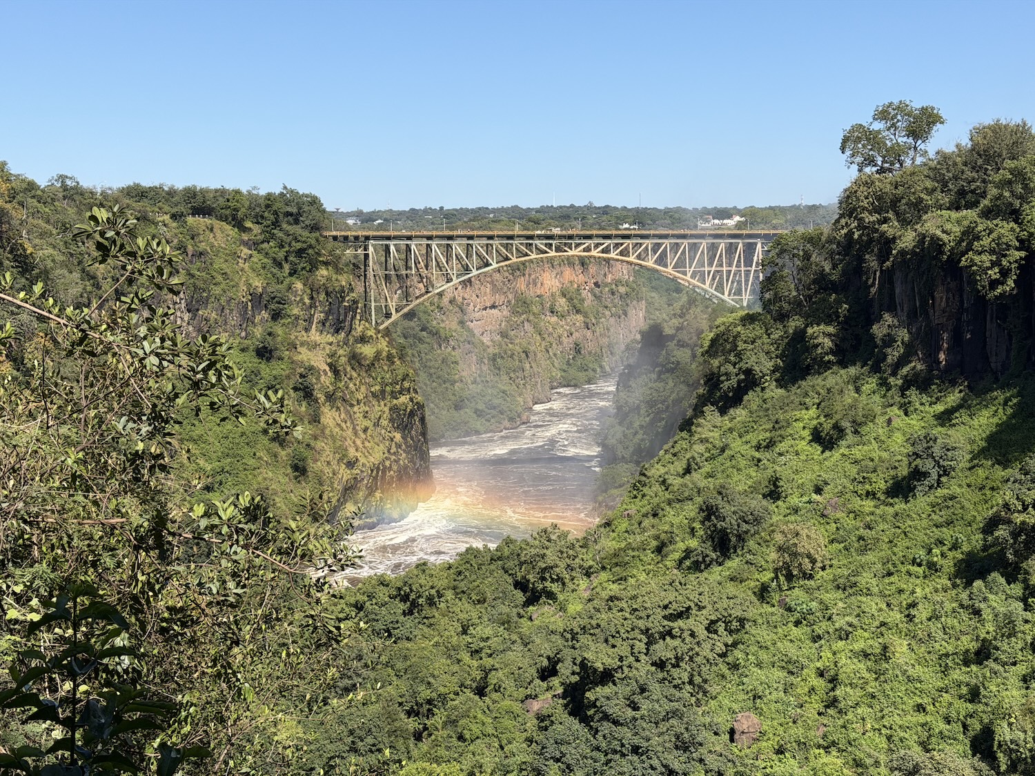 Zimbabwe Zambia border bridge seen with rainbow in front of it